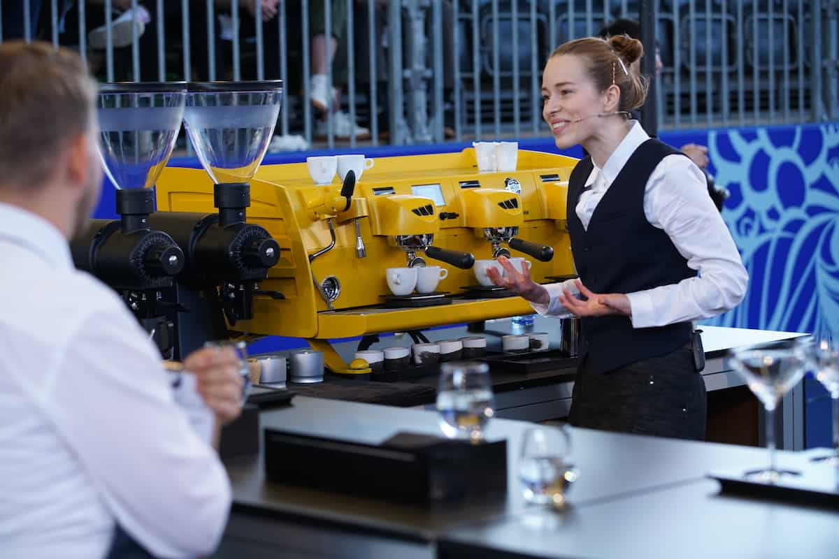 Lily, oprichter van ATRI, presenteert koffie in de finale van het World Barista Championship